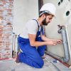 young-plumber-working-with-grey-sewer-pipes-fixin-QZBR25W.jpg